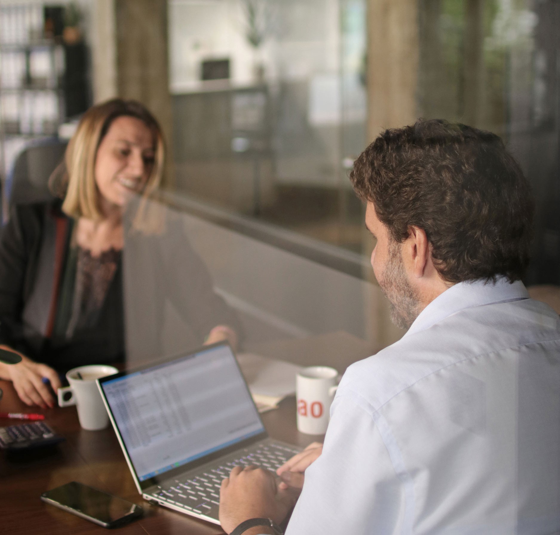 Dos compañeros trabajando con un ordenador en la oficina de la asesoría en Bilbao